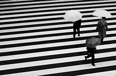 Rear view of people walking on zebra crossing