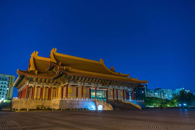 Low angle view of temple against clear blue sky at night