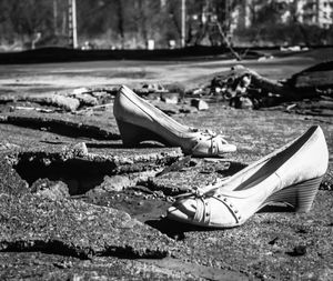 Low section of abandoned shoes on footpath