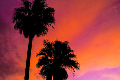 Silhouette palm trees against romantic sky at sunset