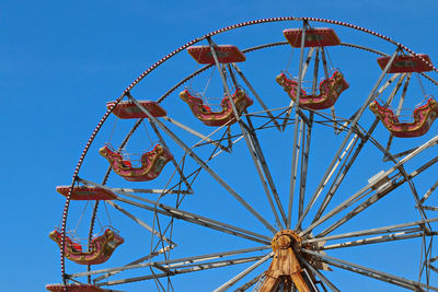 Low angle view of ferris wheel against clear blue sky