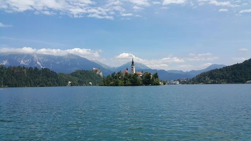 Scenic view of lake bled and mountains against blue sky