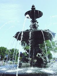Water splashing in fountain against sky