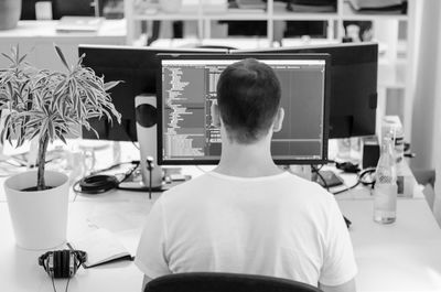 Rear view of man working in office