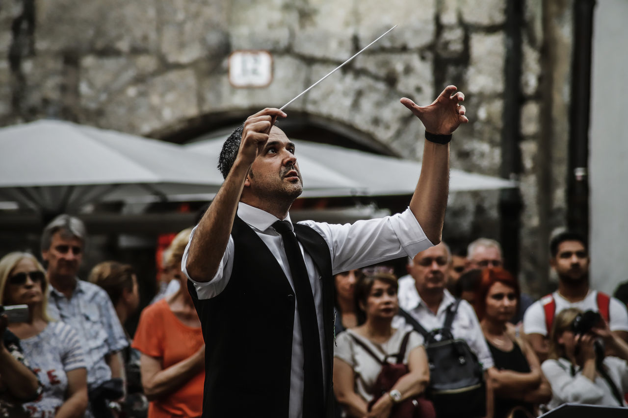 real people, men, focus on foreground, crowd, group of people, human arm, lifestyles, males, people, event, arms raised, looking, adult, waist up, young adult, standing, enjoyment, celebration, day