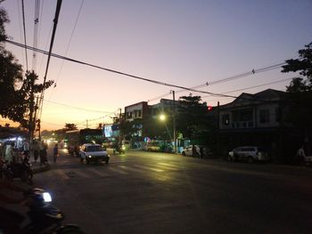 Cars on city street at sunset