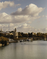 River amidst buildings in city against sky