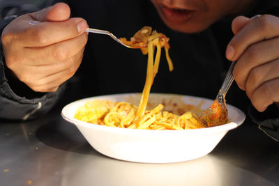 Close-up of person eating food on table