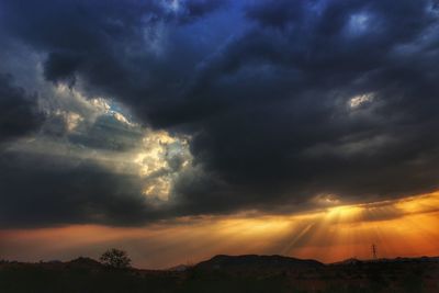 Scenic view of dramatic sky over silhouette landscape