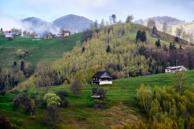 Scenic view of landscape and houses against sky