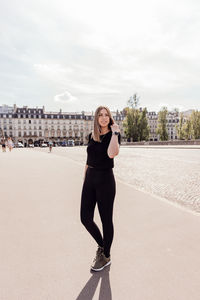 Full length portrait of woman standing against sky