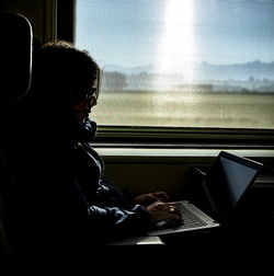 Side view of man sitting in train