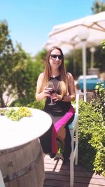 Young woman wearing sunglasses sitting outdoors