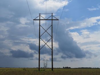 Low angle view of windmill on field against sky