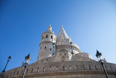 Low angle view of fisherman bastion against clear blue sky during sunny day