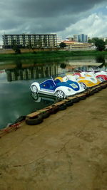 Boats moored in lake against buildings in city