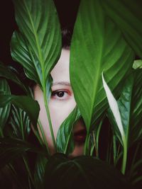 Close-up portrait of young woman seen through plants