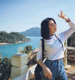 Woman shielding eyes while standing on mountain