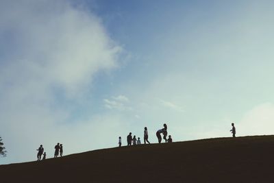 Silhouette people walking on field