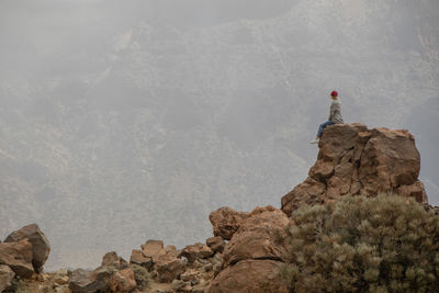 Man standing on rock against mountains