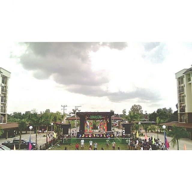 architecture, built structure, building exterior, sky, cloud - sky, transfer print, cloudy, auto post production filter, large group of people, person, day, lifestyles, cloud, city, men, outdoors, tree, railing, weather