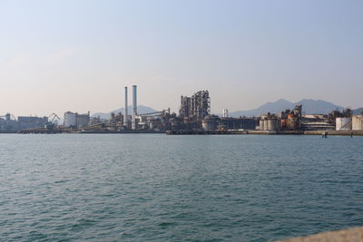 River by cityscape against sky