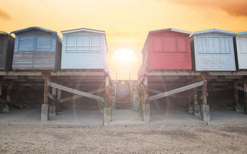 Beach huts against sky during sunset