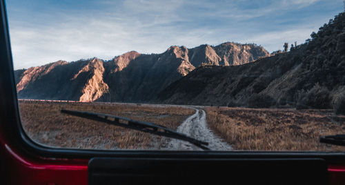 Scenic view of mountains seen through car windshield