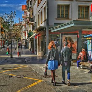 Rear view of woman walking on street in city