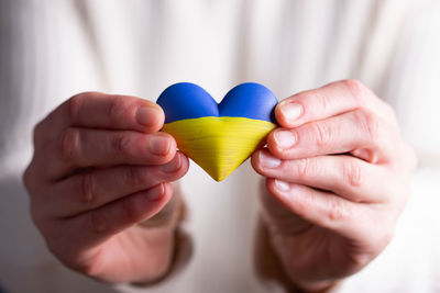 Midsection of woman holding heart shape