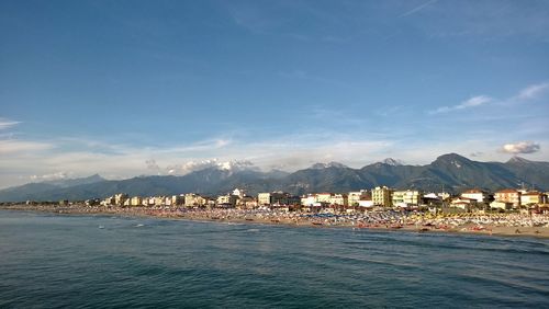 Scenic view of sea and mountains against blue sky