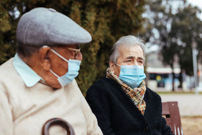 Side view of an elderly couple wearing face mask on the street as they looking away on a winter afternoon