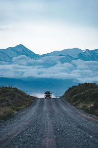 Road amidst snowcapped mountains against sky