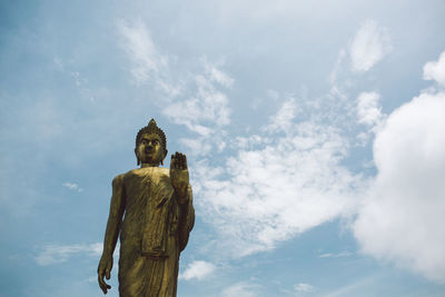 Low angle view of buddha statue against sky