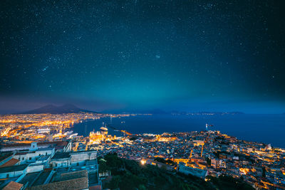 Aerial view of townscape against sky at night