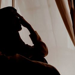 Side view of a young woman sitting at home