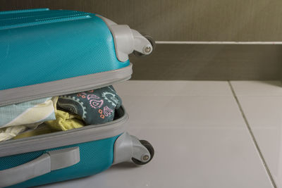 High angle view of open luggage on white tiled floor
