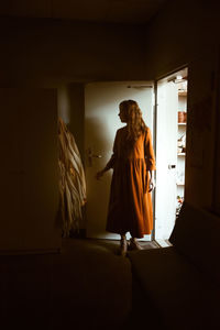 Young woman at the front door choosing an apron