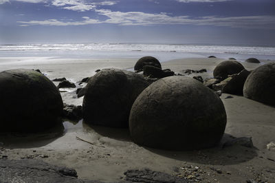 Rocks on beach against sky