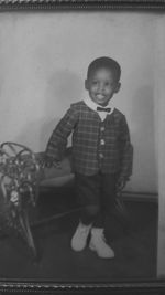 Portrait of smiling boy standing against wall