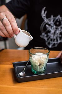 Close-up of hand holding ice cream on table