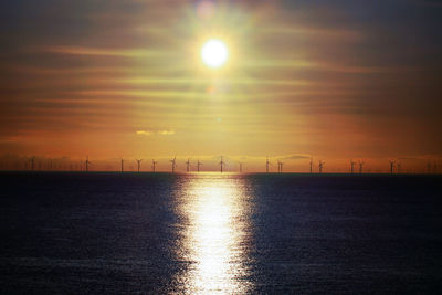 Scenic view of sea against sky during sunrise wind turbines off shore llandudno 