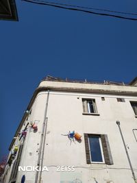 Low angle view of buildings against clear blue sky