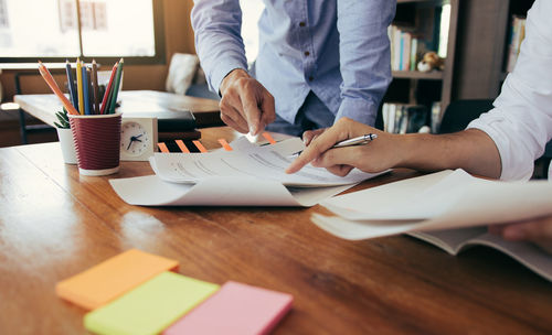 Midsection of businessmen working at office