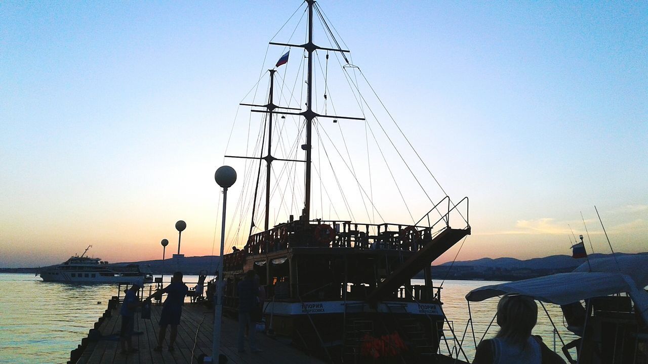 nautical vessel, water, sunset, transportation, clear sky, mode of transport, sea, sky, silhouette, outdoors, nature, mast, moored, real people, sailboat, harbor, scenics, beauty in nature, day