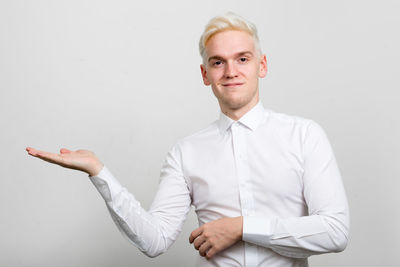 Portrait of man gesturing against white background