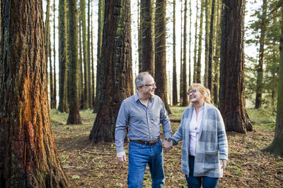 Retired romantic couple walking through the forest.