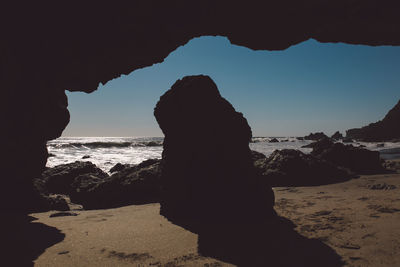Silhouette of rock formations on beach