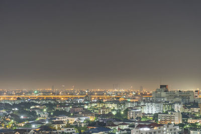 Aerial view of illuminated cityscape against sky at night