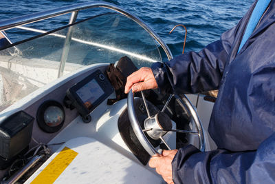 Midsection of man sailing in sea